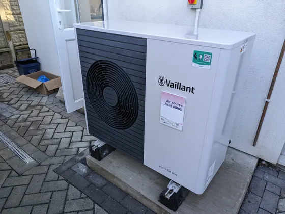 Air-source heat pump outdoor unit next to a house